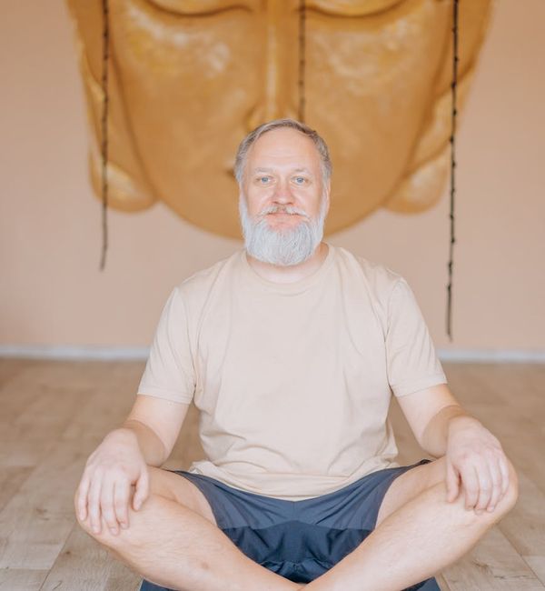 Person meditating in a lotus pose with a calm, serene expression.