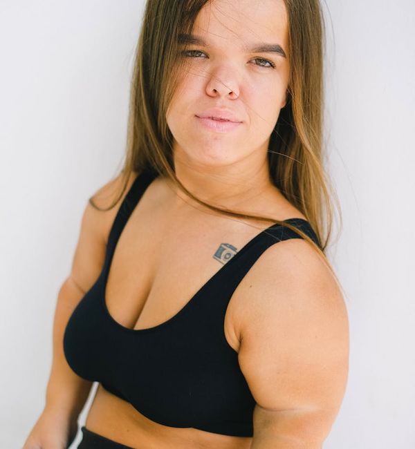 Portrait of a smiling, confident woman in a wellness studio.